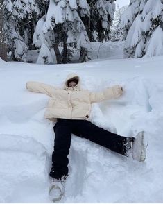 a person laying in the snow with their arms spread out