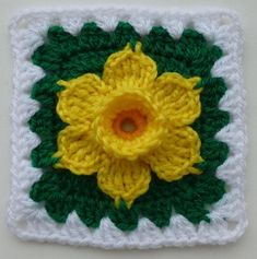 a crocheted square with a yellow flower on it