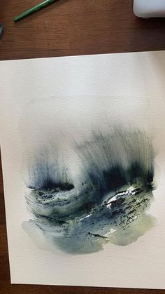 a watercolor painting on paper with paintbrushes next to it