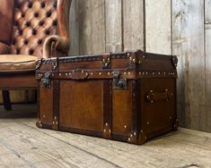 an old trunk sitting on the floor next to a chair