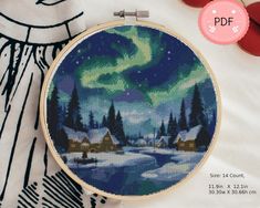 a cross stitch pattern with the image of a snowy night and aurora bores in the sky