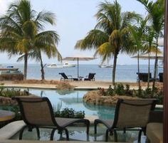 some chairs and tables by the water