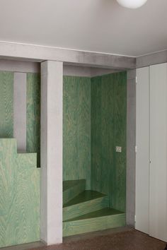 an empty room with green walls and steps