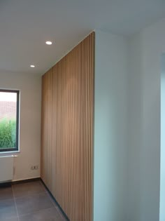 an empty room with wooden slats on the wall