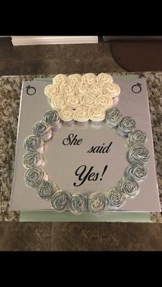 there is a cake that has roses in the shape of a sheep and says she said yes