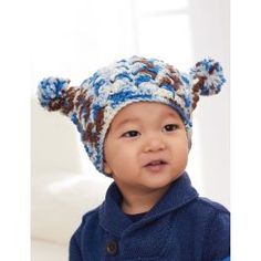 a small child wearing a blue and brown hat