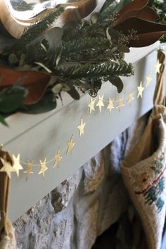 christmas stockings hanging from a mantel with gold stars