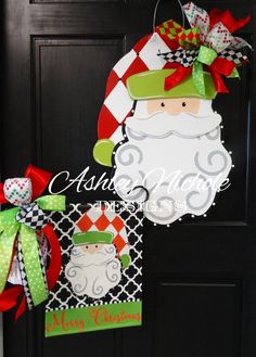 a christmas door hanger with a santa clause on it's face and a green bow