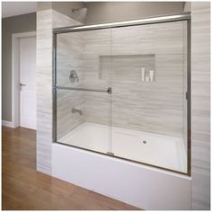 a bathroom with a glass shower door and wood flooring on the side of the room