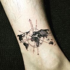 a world map tattoo on the ankle with arrows and dots around it in black ink