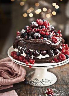 a chocolate cake with berries and whipped cream on top