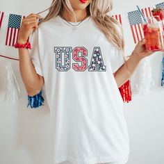 Celebrate Independence Day with Ease on Our 4th of July Cotton T-Shirt! Are you struggling to find the perfect outfit for your 4th of July celebration this year? Look no further! Our high-quality 4th of July themed t-shirt provides a quick and easy wardrobe solution for women and families.  Featuring soft cotton fabric and a quality print, our t-shirt offers comfort and style all in one. Say goodbye to the stress and time-consuming process of searching for the ideal outfit - our themed t-shirt h Patriotic American Flag Print T-shirt For Summer, Patriotic Crew Neck T-shirt For Spring, Patriotic Shirt With American Flag For Independence Day, Patriotic American Flag Shirt For Independence Day, American Style Flag Print Short Sleeve Top, American Style Short Sleeve Tops With Flag Print, American Style Tops With Flag Print And Short Sleeve, White Americana Tops For Summer, White Americana Style Tops For Summer