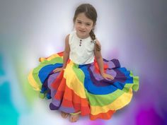 This super twirly rainbow dress is something like you have never seen before. It is so much more! There are flounces upon flounces sewn together to make this amazing dress. The dress falls below the knee to a classy tea length. The dress consists of 14 tiers and seven yards of fabric in the skirt. The bodice is fully lined and it has rainbow top stitching with snap closure in the back. Notice the different color snaps to coordinate with the rainbow theme skirt. The front has three small red and Whimsical Multicolor Twirl Dress For Spring, Playful Rainbow Dress With Ruffles, Whimsical Multicolor Twirl Dress For Summer, Fitted Rainbow Dresses In Playful Style, Playful Fitted Rainbow Dress, Fitted Playful Rainbow Dress, Multicolor Ruffled Twirl Dress For Playtime, Multicolor Ruffle Twirl Dress For Playtime, Fun Multicolor Twirl Dress With Ruffles