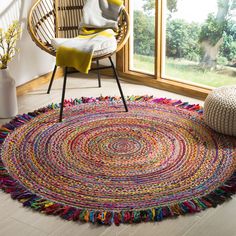 a round rug with multicolored fringes on the floor next to a chair