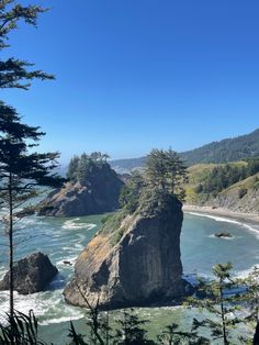 the coast is surrounded by large rocks and pine trees