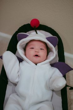 a baby in a costume laying on the floor