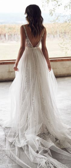 the back of a woman's wedding dress in front of an open window, with her hands on her hips