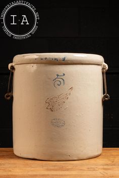 a large white bucket sitting on top of a wooden table