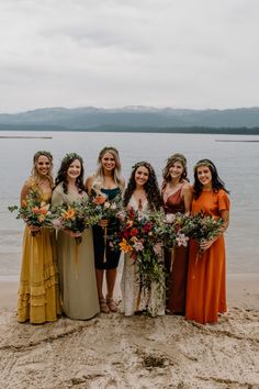 a group of women standing next to each other on top of a beach