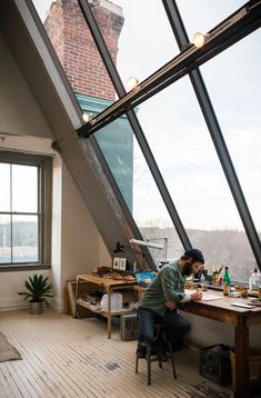 a man sitting at a table in front of a window with lots of windows on it