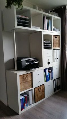 a white bookcase filled with books next to a window