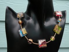 a necklace with multicolored glass beads on a mannequin