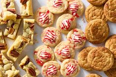 many different types of desserts on a white plate with red and white icing