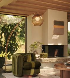 a living room filled with furniture and a fire place next to a large window covered in plants