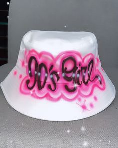 Designs by Galveston Airbrush! ♡ Feel free to contact me with any questions or custom orders. ✧ Our Designs on these cute bucket hats are handmade with the artists' skilled Hands and that makes each item unique ✧ My designs are Airbrushed on white or pink bucket hats. Please select desired color from the drop-down menu. Each design includes up to TWO names or words with up to THREE specified COLORS. SIZES: One Size for ADULTS DESIGN PLACEMENT: All designs are airbrushed on the FRONT of our cute Casual Hand Painted White Hat, Casual White Hand Painted Hats, White Wide Brim Hat For Streetwear, Adjustable Bucket Hat With Letter Print For Beach, Adjustable Letter Print Bucket Hat For Beach, Cute White Bucket Hat With Curved Brim, Cute White Bucket Hat With Short Brim, White Bucket Hat As Gift, Adjustable White Bucket Hat