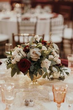 the centerpieces on this table are red and white roses