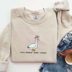 "The perfect funny cowboy vibe for a stylish silly goose! This sweatshirt is made from a soft, mid-weight cotton blend fabric for easy layering when it gets chilly, or throw it on for comfort. It makes a great gift, and we think this cozy sweatshirt has all the qualities a goose lover could ever want.  Gildan 18000 Heavy Blend Crewneck Sweatshirt Sweatshirts are unisex, classic fit.  Please refer to the size chart in the listing photos for details. Easy measuring tip: Take your favorite tee, lay it on a flat surface and measure the width (armpit to armpit) and the length (top to bottom) Recommended Care Instructions  Machine wash inside out, tumble dry low  Do not use bleach, do not dry clean  Do not iron directly on graphic  All items are made to order. They will ship within one week from Duck Sweatshirt, Western Sweater, Goose Sweatshirt, Western Sweaters, Quilt Size Chart, Silly Goose, Workout Inspiration