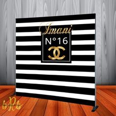 a black and white striped backdrop with gold lettering that says, amani no 16