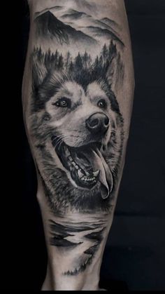 a man's leg with a black and white tattoo of a wolf on it