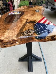 a wooden table with an american flag design on it and some other things in the background