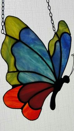 a stained glass butterfly hanging from a chain