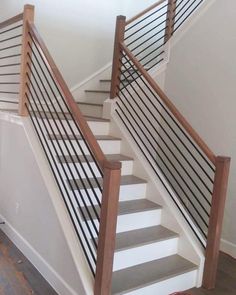 there is a white stair case next to the bannister in this house with wood handrails