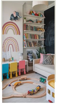 Colorful children's playroom with rainbows on the wall, a train set on the floor, and shelves filled with books and toys.