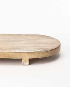 a round wooden table with two legs on the top and one leg raised up to the side