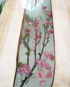 pink flowers are painted on the inside of a glass vase with wood trimmings