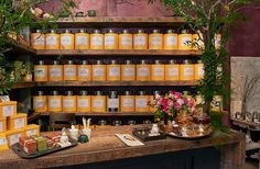 the shelves are full of honey jars with flowers and candles on them, along with other items