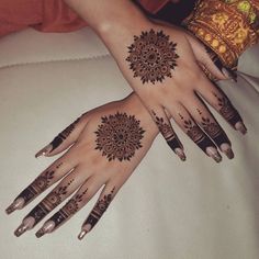 two hands with henna tattoos on them