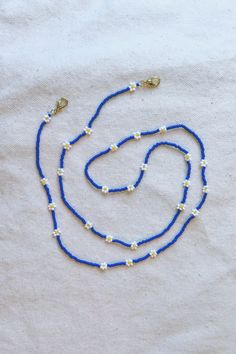 "Versatile chain for glasses / sunglasses that doubles as a necklace and mask chain. Designed and crafted for daily wear. This chain is super special! It has a dainty, delicate feel and can easily be dressed up or down.  - Made with opaque, matte finish Japanese beads in gorgeous, vibrant royal blue - White and yellow Czech glass bead daisies are grouped into threes. (Makes a cute pattern when wrapped into a necklace.) - 18k gold-plated hardware - Double strung on the strongest and most flexible beading thread for exceptional durability and drape (no stretch, no crimping)  - 24\" length   Production time is approx 3 days plus shipping. Rush production and rush shipping available as a shipping upgrade at checkout. Please see other listings for more styles. Message for custom option." Blue Round Bead Necklaces As Fashion Accessory, Blue Beaded Chain Jewelry For Summer, Blue Round Bead Necklaces, Blue Beaded Everyday Necklace, Blue Necklaces With Round Beads As Fashion Accessory, Blue Necklace With Round Beads As Fashion Accessory, Summer Blue Beaded Chain Jewelry, Blue Beaded Necklaces With Lobster Clasp For Festival, Blue Beaded Necklace For Festival With Lobster Clasp