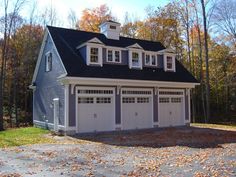 a two car garage with three dormers on the roof