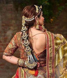 the back of a woman's dress with gold and red accents