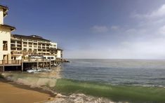 an ocean front hotel with waves crashing on the beach