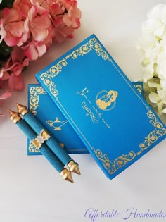 two blue notebooks sitting next to some flowers