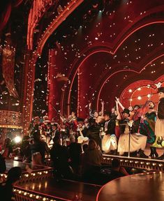 a group of people standing on top of a stage with confetti in the air