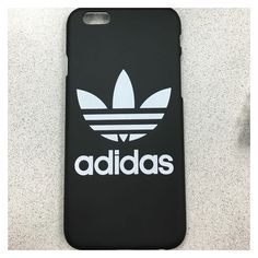 an iphone case with the adidas logo on it, sitting next to a cell phone