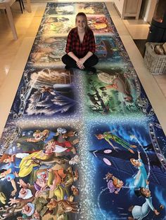 a woman sitting on the floor in front of an art piece that looks like disney characters