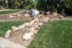 a garden with rocks in the middle and grass on the other side that is being laid out